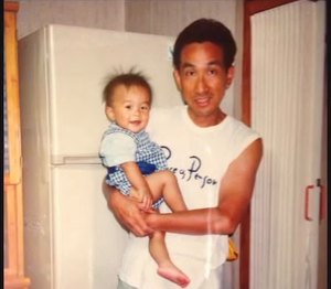 幼いころの久保を抱く父（家族の写真）